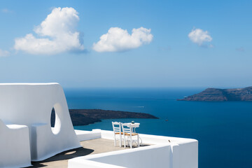 White architecture in Santorini island, Greece. Two chairs on the terrace with sea view.
