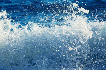 Splash of the sea wave with foam close up. Abstract sea wave background.
