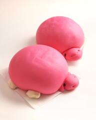 The turtle buns-Chinese steamed bun, shaped into turtles with a coloured layer of pink or yellow. Local call it "Mee Koo". Isolated on white background