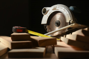 Circular saw and wooden boards close up background. Front view. Woodwork.