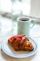 Delicious freshly baked raspberry croissant and a mug of black coffee - 741293608