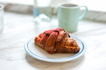 Delicious freshly baked raspberry croissant and a mug of black coffee - 741293656
