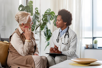 Doctor specialist consulting a patient at the clinic. A female doctor is talking with a female elderly patient.
