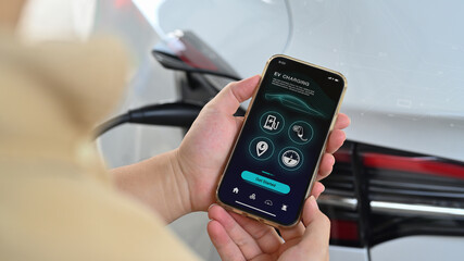 Businessman holding smartphone with smart EV mobile application