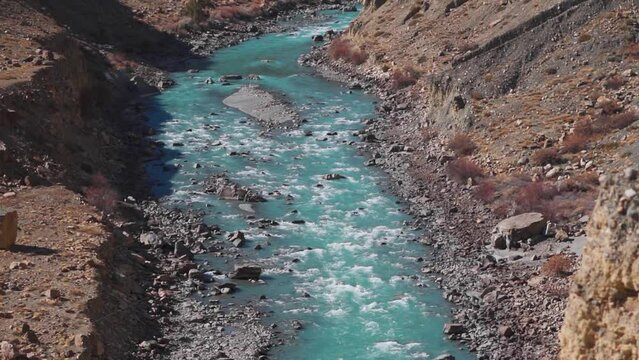 High angle shot of Spiti river flowing between mountains at Spiti Valley in Himachal Pradesh, India. River flowing with mountains on the side of it in Spiti. River between the Himalayan mountains.