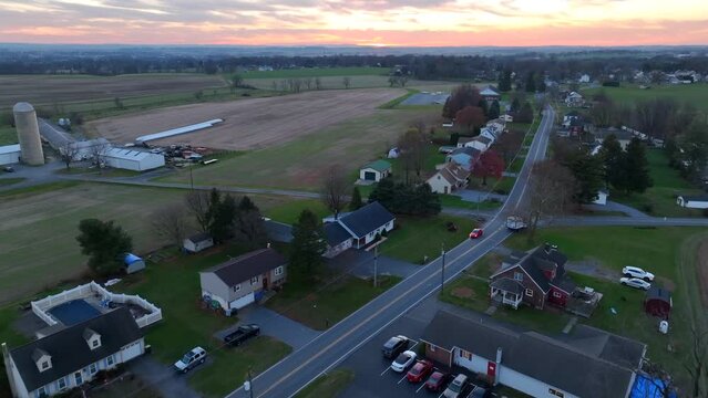 Rural Pennsylvania during late autumn and winter sunset. Aerial tracking shot above houses with farmland.