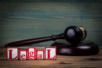 LEGAL. Red alphabet letters and judge's gavel on wooden background. Laws and justice concept