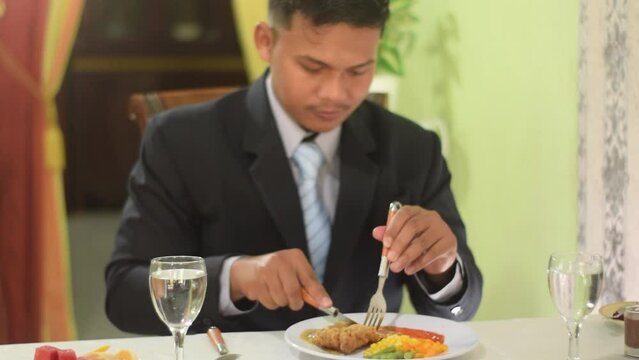 A Man Dressed In A Suit Like A Businessman Was Tasting Appetizers Such As Jelly And Bread.