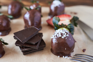 Chocolate dipped strawberries on a wooden board. Selective focus.