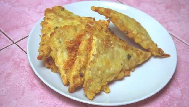 Video footage of the process of serving fried tempeh, a typical Indonesian food. Fried tempeh with a savory and crunchy taste.