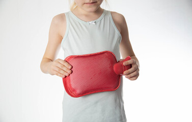 The girl applies a red heating pad with warm water to improve digestion and the flow of bile, close-up