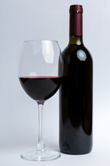 Glass of red wine and a bottle on colored table. Flat lay, top view wth copy space