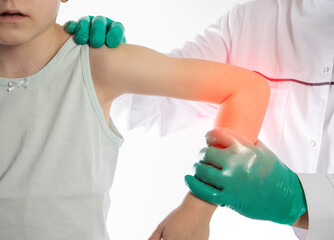 The hands of a traumatologist doctor in green medical gloves examine the girl s damaged elbow...