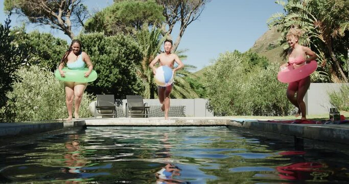 Diverse friends enjoy a sunny day at an outdoor pool, with copy space