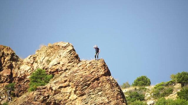 Male base jumper jumps off edge of volcanic rock and opens his parachute. Extreme sport. Sky diving and parachuting daredevils B.A.S.E jump from great heights. Slow motion