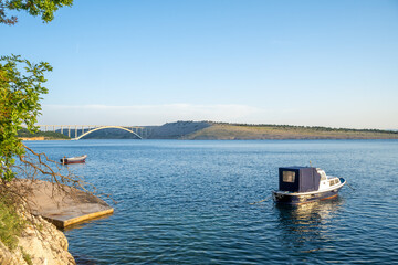 View of Tito's bridge from Kraljevica in summer with a boat in foreground, Croatia