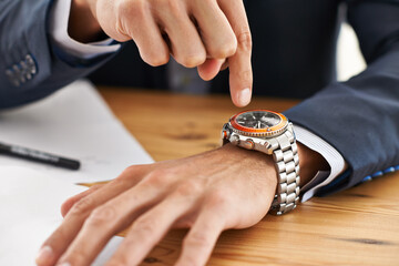 Hands, desk and wristwatch to check time for deadline at office, paperwork and schedule for business. Closeup, interview and appointment for work with commitment, punctual and plan for meeting.