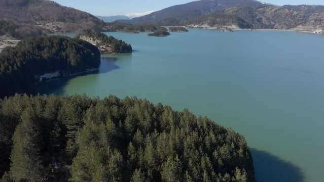 Aerial tilt up view Aoos spring lake Metsovo Greece sunny day blue sky