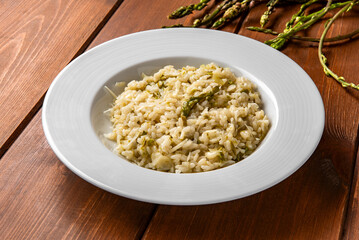 Delizioso risotto con asparagi selvatici e scaglie di pecorino, cibo italiano vegetariano 