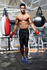 Portrait, fitness and man skipping in gym for fight preparation, training or boxing cardio....