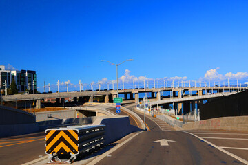 View of highway and highway bridge across above it, with a clear blue sky background. Freeway entrance. East Interstate California 