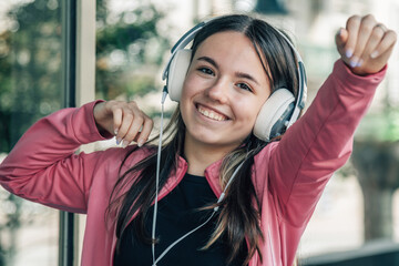euphoric girl teenager with headphones on the street
