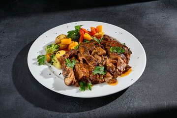 Beef brisket with roasted vegetables on a white plate