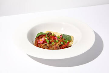 Braised beef with vegetables and mushrooms served with mashed potatoes, on an isolated white background, a hearty meal