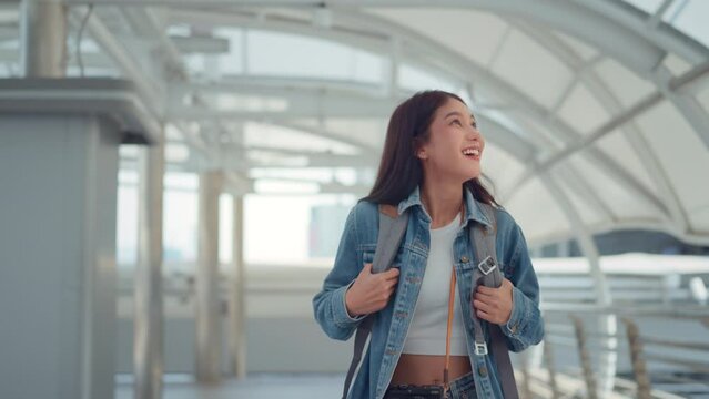 Portrait of cheerful beautiful tourist asian female in good mood with camera walking in urban city