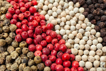 Pepper mix of red, black, white and green peppercorns background. Aromatic, organic spice. Top view.
