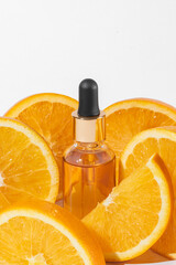 Vitamin c serum extract with sliced oranges on white background. Natural skin care cosmetics. Mockup with copy space