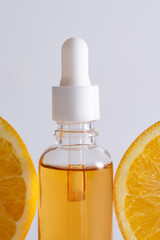 Natural vitamin c serum, skincare, essential oil products. Bottle of vitamin C serum with fresh juicy orange fruit. Beauty product branding mock-up.
