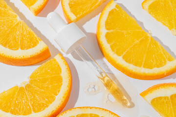 Cosmetic pipette with vitamin C serum on white background with oranges close-up. Stylish concept of organic essences, beauty and health products. Modern apothecary. Close up