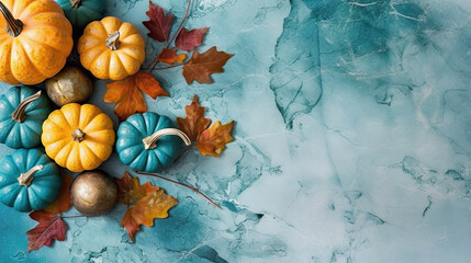 A group of pumpkins with dried autumn leaves and twig, on a teal color marble