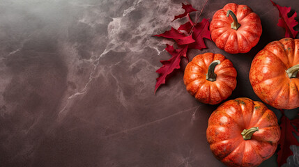 A group of pumpkins with dried autumn leaves and twig, on a scarlet color marble - obrazy, fototapety, plakaty
