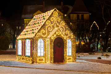 Small fairy tale house decorated with twinkling garlands lights and glittering patterns, night city...