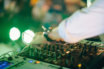 DJ Hands creating and regulating music on dj console mixer in concert outdoor. and guitar shows