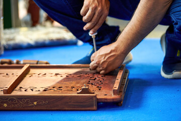 A worker is installing traditional Chinese wooden furniture