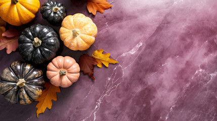 A group of pumpkins with dried autumn leaves and twig, on a vivid purple color marble