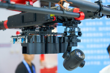 Close-up of professional video camera hanging on tripod in exhibition hall