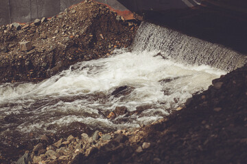 Liquid water flows through rocky fluvial landforms in a natural landscape
