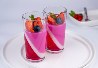 Fruit jelly dessert or panna cotta with fresh strawberries and blueberries, banner, copy space, menu, template for texts on white background