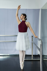 Elegant Asian ballet dancer woman standing and practicing classic ballet in rehearsal room