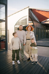 Happy family of father, mother and two sons spending time together outdoors.