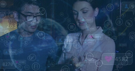 Image of social media icons over diverse couple of server room workers