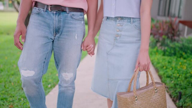 Close-up of a happy boyfriend and girlfriend enjoying spending time together, cuddling and having fun, and holding hands in a green space filled with romantic love.