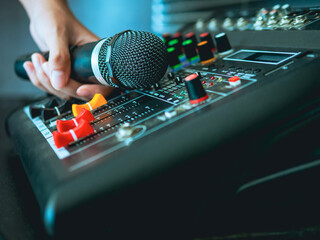 Hand Sound engineer  holding microphone on sound mixer in live broadcasting studio producer for...