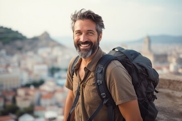 Portrait of a smiling man with backpack on top of a hill