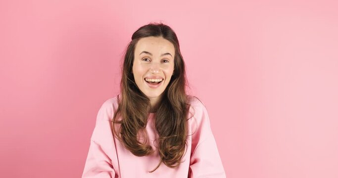 Amazed excited woman hairstyle in pink long sleeves top open mouth in surprise looking at camera with big eyes, shocked isolated on pink background. Oh my god wow, yes gesture, win symbol.