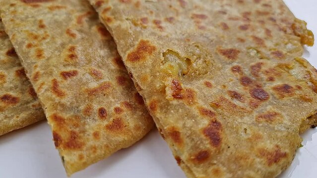 Pan shot of Indian famous food aloo paratha or flatbread served with yogurt and chutney